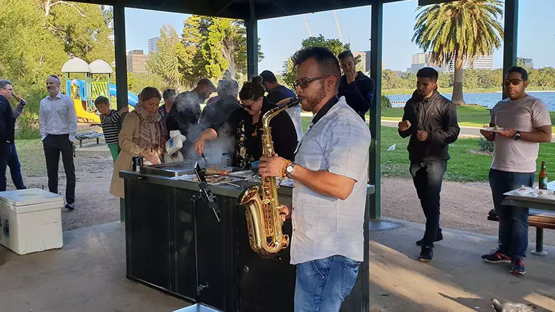 imc emplee plays the saxaphone at a barbeque