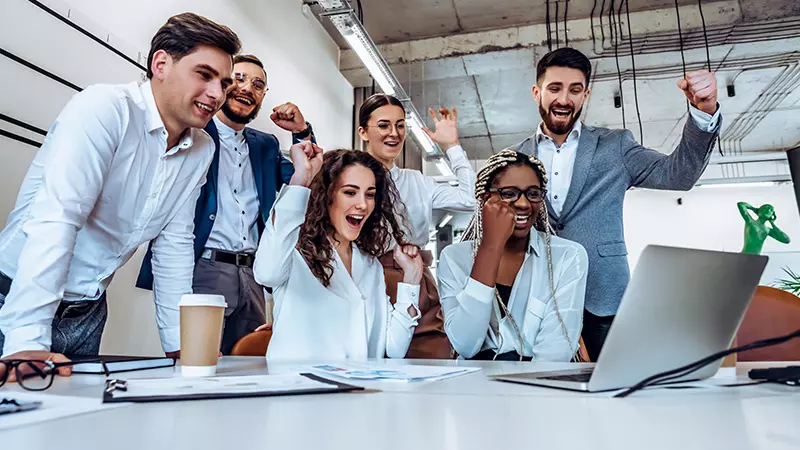 group of employees around computer