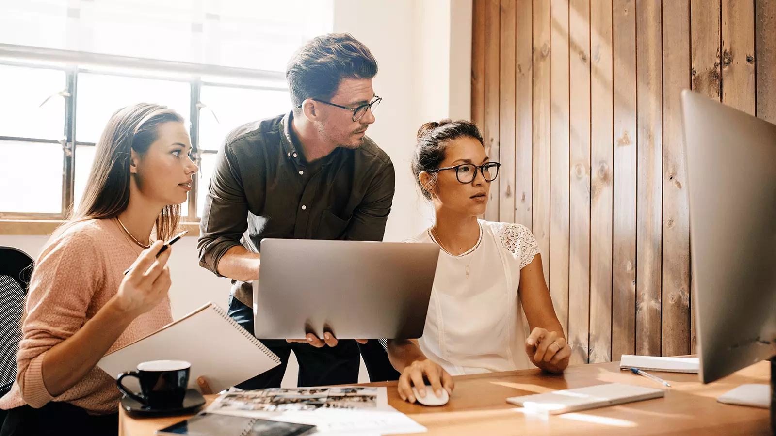 group of employees around computer