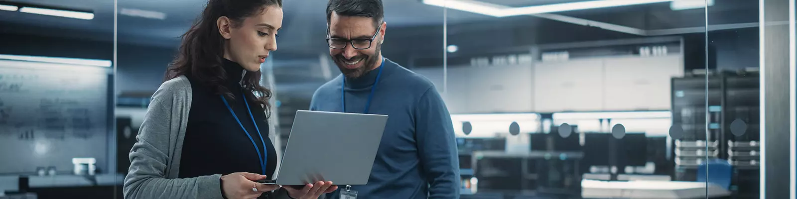 two coworkers discuss cybersecurity at a computer