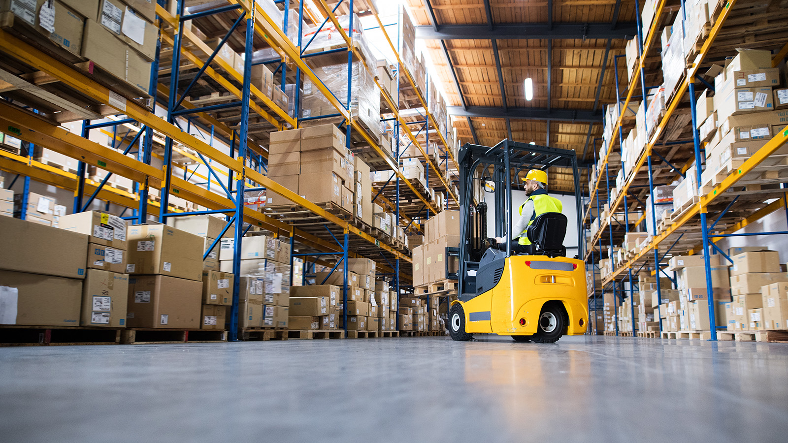 person using forklift in warehouse