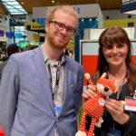 imc employees at conference with soft toy
