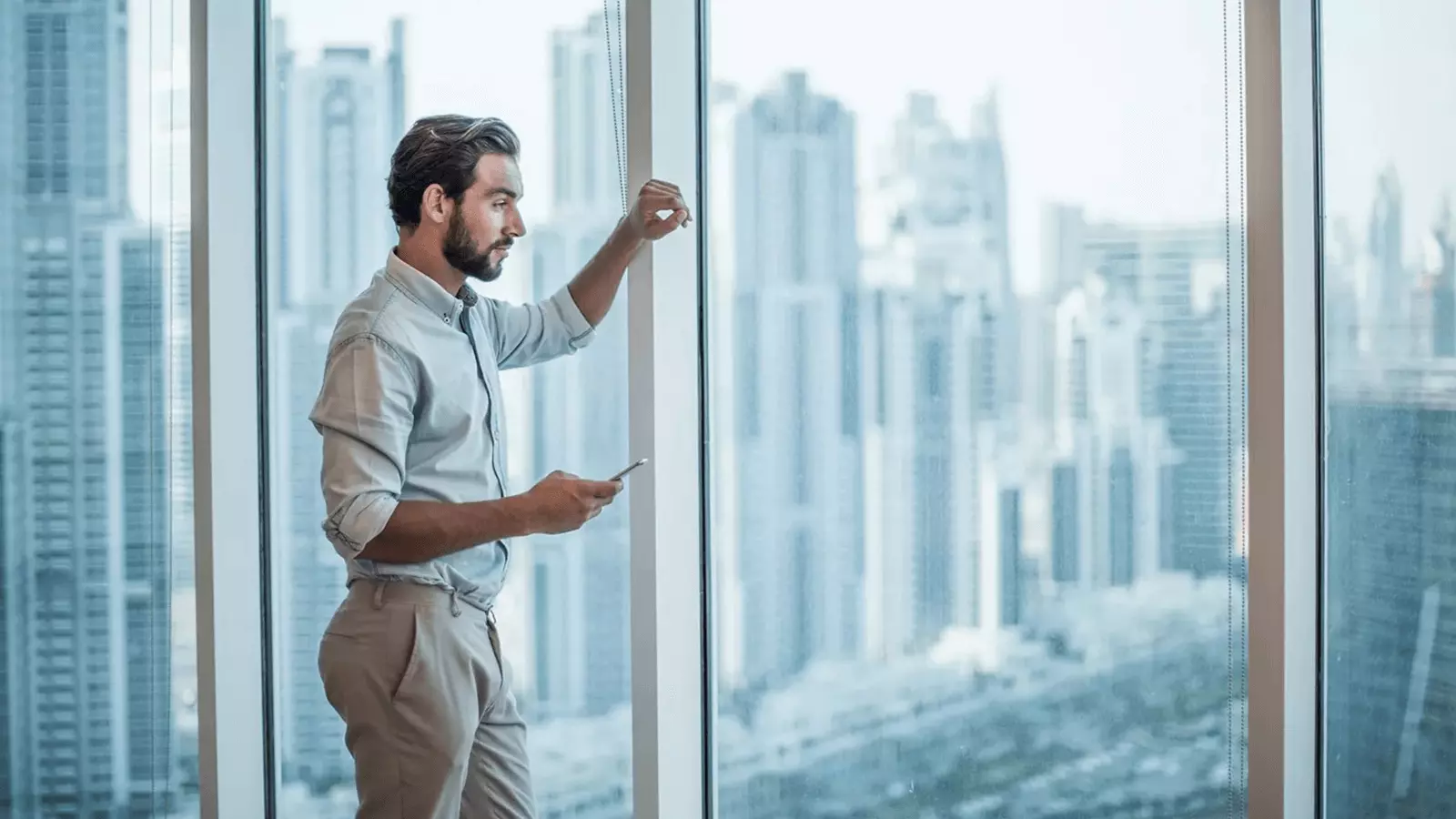 man looking out window in finance building