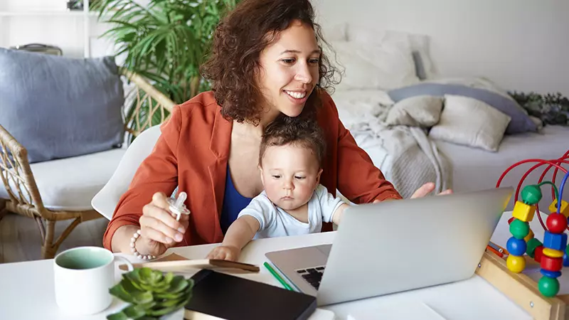person working from home with infant on lap