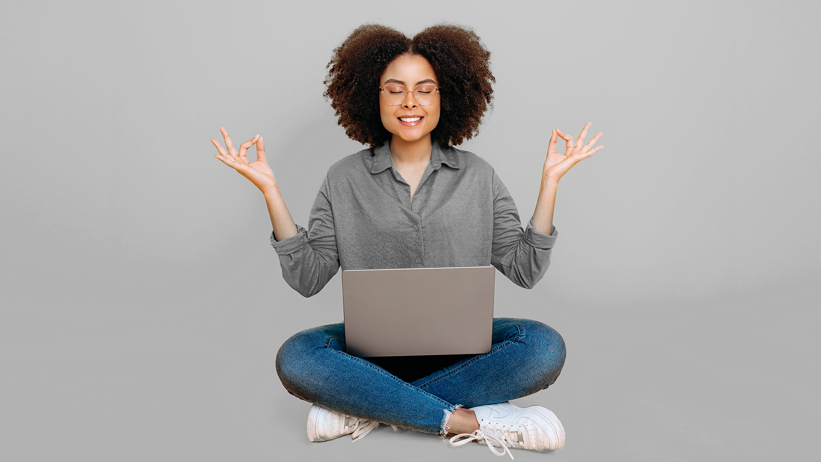 peaceful woman in yoga pose with laptop