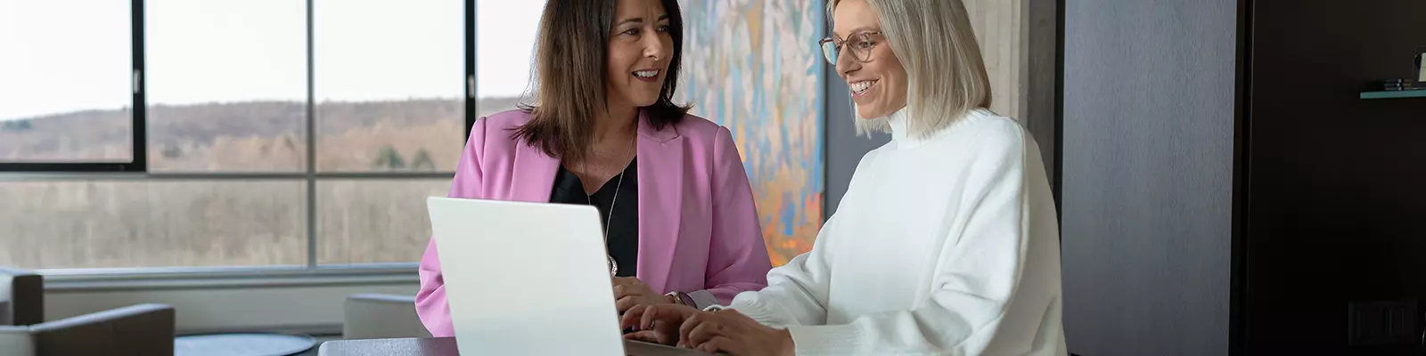 Zwei Frauen nebeneinander an einem Laptop